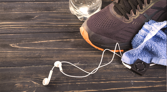 Chaussures de sports, serviette, bouteille d'eau et Ipod touch sur une table noire.