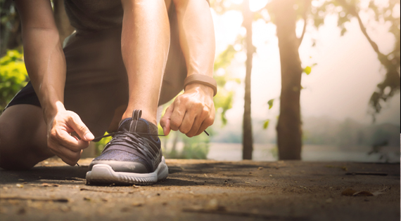 Homme faisant du running en train de lacer ses chaussures