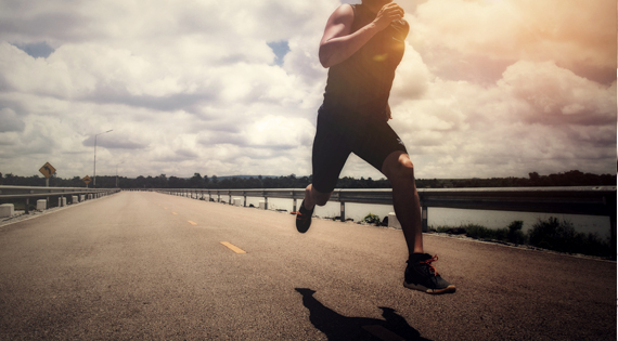 Homme courant le long d'une route.